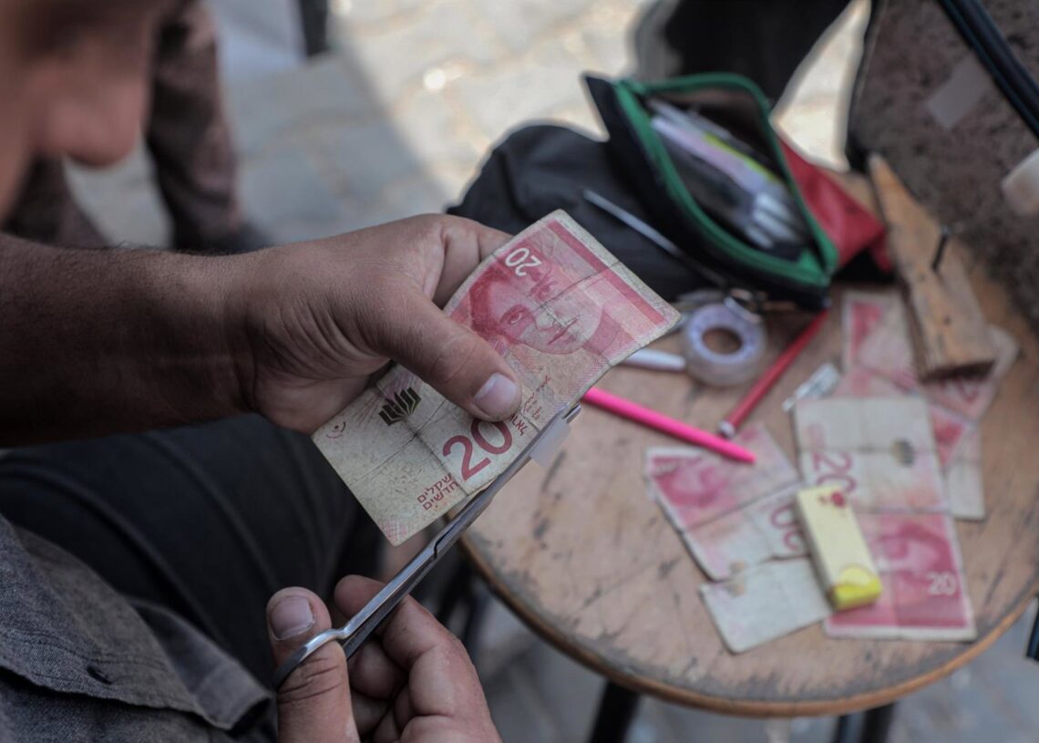 Archivo - Un palestino repara billetes deteriorados en Jan Yunis (Gaza) Europa Press/Contacto/Rizek Abdeljawad - Archivo