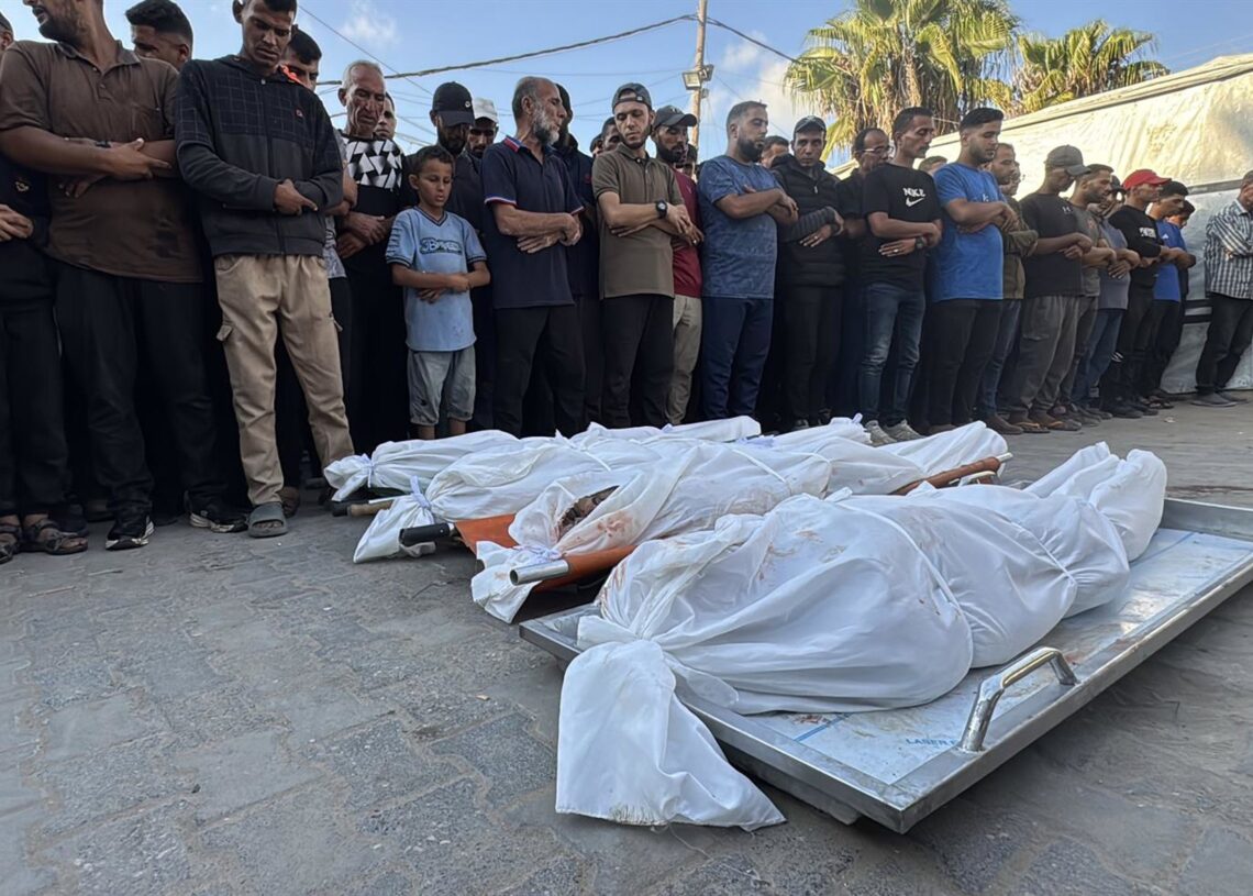 Un grupo de personas contemplan los cuerpos de otros gazatíes fallecidos en un ataque israelí, frente el hospital Shuhada al Aqsa de Deir al Balá, en el centro de la Franja de GazaEuropa Press/Contacto/Ahmed Ibrahim