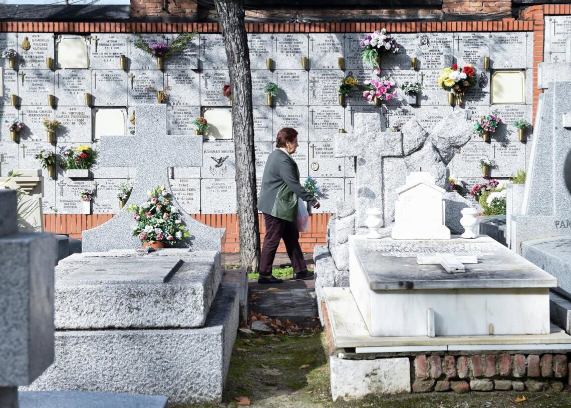 Archivo - Una mujer lleva flores a un ser querido, en el Cementerio de la AlmudenaGustavo Valiente - Europa Press - Archivo