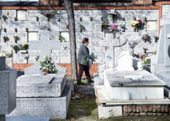 Archivo - Una mujer lleva flores a un ser querido, en el Cementerio de la AlmudenaGustavo Valiente - Europa Press - Archivo