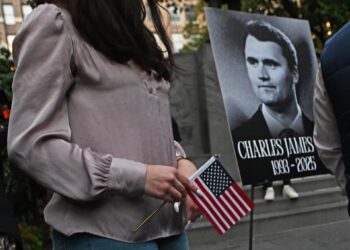 Archivo - 12 September 2025, US, New York: A woman holds a US flag next to a photo of Charlie Kirk, the US conservative activist and co-founder of Turning Point USA, who was shot dead at an event at Utah Valley UniversityAndrea Renault/ZUMA Press Wire/d / DPA - Archivo