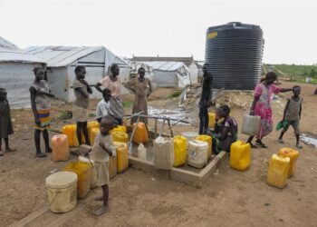 Archivo - Mujeres y niños en un pozo de agua en un campamento de desplazados de la ONU en la capital de Sudán del Sur, Yuba UNICEF/UN0263300/RICH / SEBASTIAN RICH - Archivo