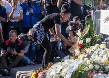Imagen de archivo de una mujer depositando flores en recuerdo de las víctimas del derrumbe de la estación de tren de Novi Sad.Europa Press/Contacto/Krisztian Elek