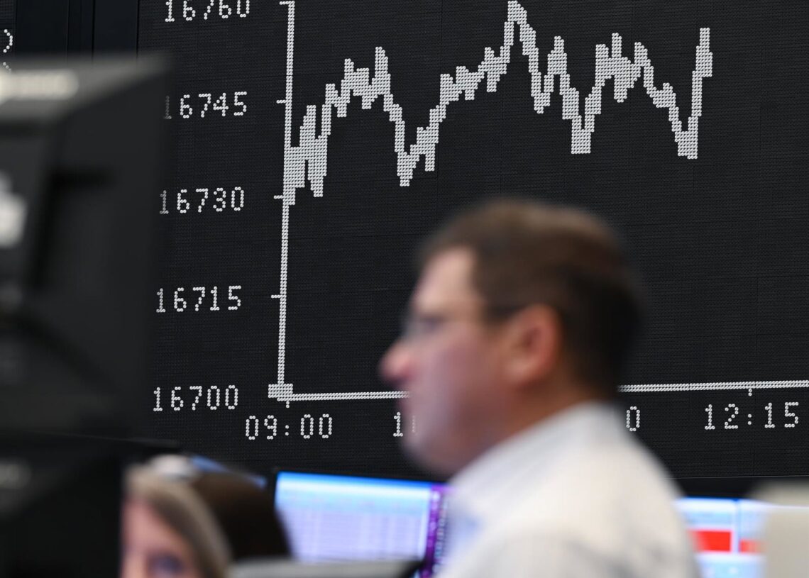 Archivo - 29 December 2023, Hesse, Frankfurt_Main: Stock exchange traders talk to each other in the trading hall of the Frankfurt Stock Exchange in front of the display board showing the Dax curve.Arne Dedert/dpa - Archivo