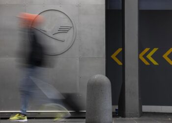 Archivo - 29 September 2025, Hesse, Frankfurt/Main: A man walks in front of a Lufthansa logo at Frankfurt Airport. Company sources have revealed that the Group intends to cut a fifth of its administrative jobs in the coming years.Hannes P. Albert/dpa - Archivo
