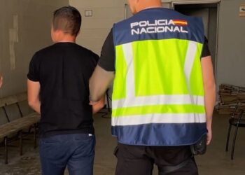 Uno de los arrestados, escoltado por un agente de la Policía Nacional.POLICÍA NACIONAL