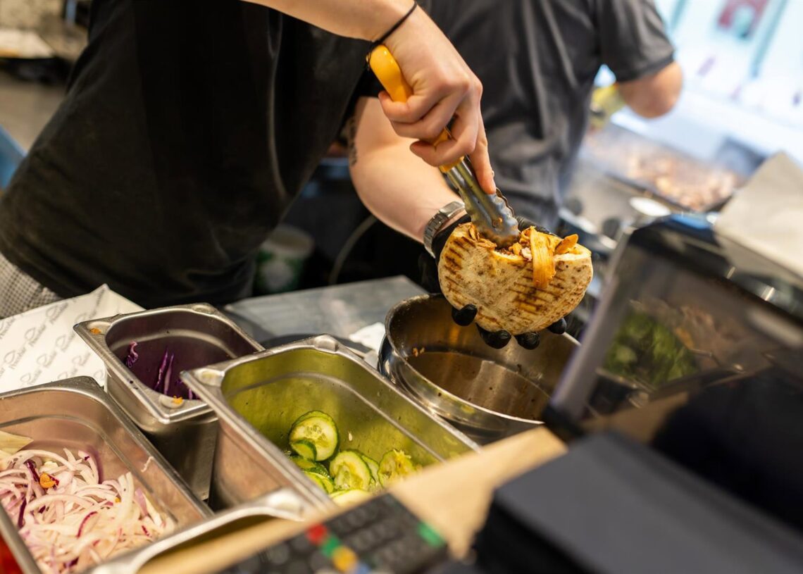 PRODUCTION - 07 November 2025, Baden-Württemberg, Karlsruhe: An employee prepares an Octopus Doener sandwich at the "Pescobar" restaurant.Philipp von Ditfurth/dpa