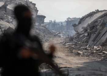 Archivo - Calles y edificios destruidos de fondo en la ciudad de Gaza, tras la figura de un combatiente de las brigadas Al Qassam, el brazo armado de HamásEuropa Press/Contacto/Omar Ashtawy