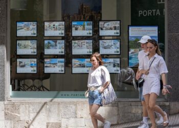 Archivo - Varias personas pasan junto a los anuncios de viviendas en venta en una inmobiliaria.Tomàs Moyà - Europa Press - Archivo