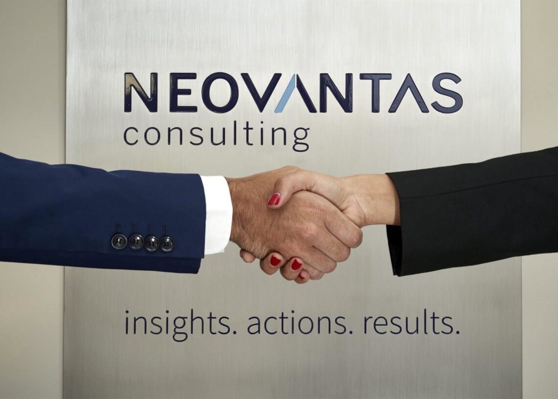 Archivo - Dos personas se estrechan la mano frente al logo de Neovantas.NEOVANTAS - Archivo