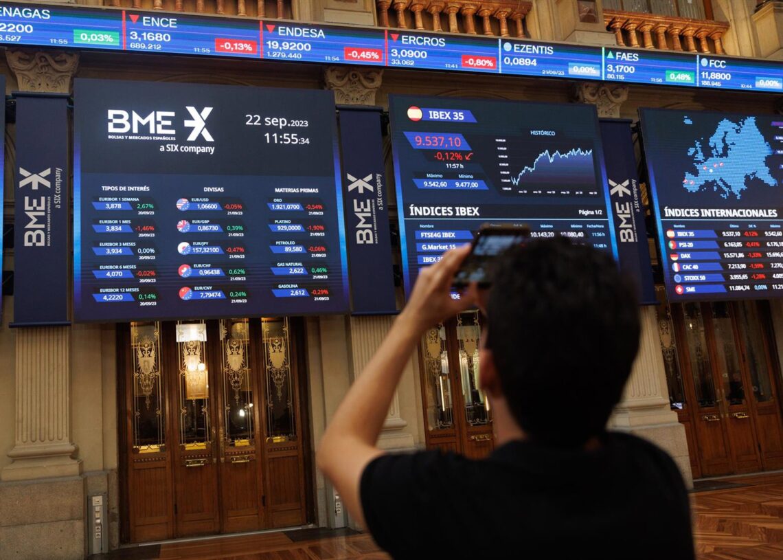 Archivo - Una persona fotografía paneles del Ibex 35 en el Palacio de la Bolsa, a 22 de septiembre de 2023, en Madrid (España). Eduardo Parra - Europa Press - Archivo