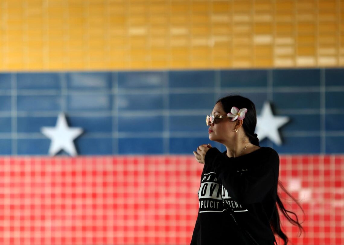 Archivo - Una mujer junto a un mural de la bandera venezolana en la ciudad de Valencia (Venezuela)Europa Press/Contacto/Juan Carlos Hernandez