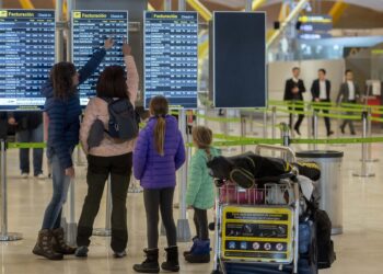 Archivo - Varias personas observan las salidas de los vuelos.Alberto Ortega - Europa Press - Archivo