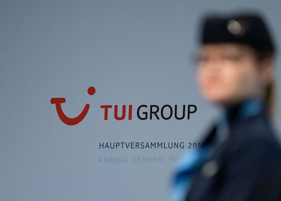 Archivo - FILED - 12 February 2019, Lower Saxony, Hannover: A Tui stewardess stands in front of the company logo at the Annual General Meeting of Tui AG. Peter Steffen/dpa - Archivo