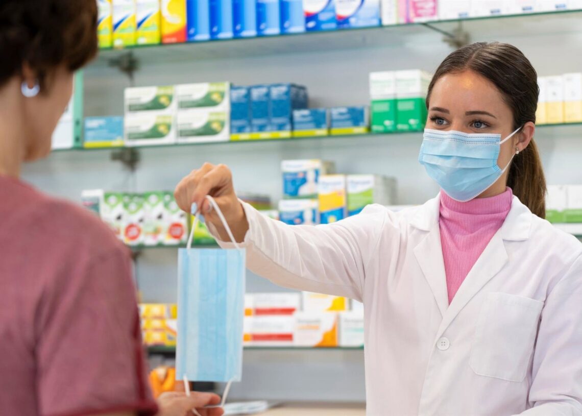 Farmacéutica vendiendo una mascarilla.COFARES