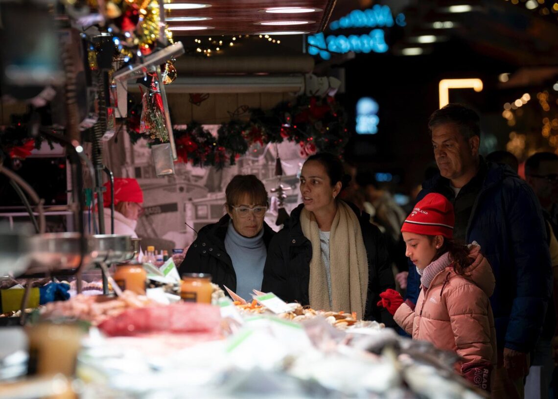 Archivo - Varias personas miran el género expuesto, en el Mercado de la Boquería, a 14 de diciembre de 2023, en Barcelona, Catalunya (España). David Zorrakino - Europa Press - Archivo