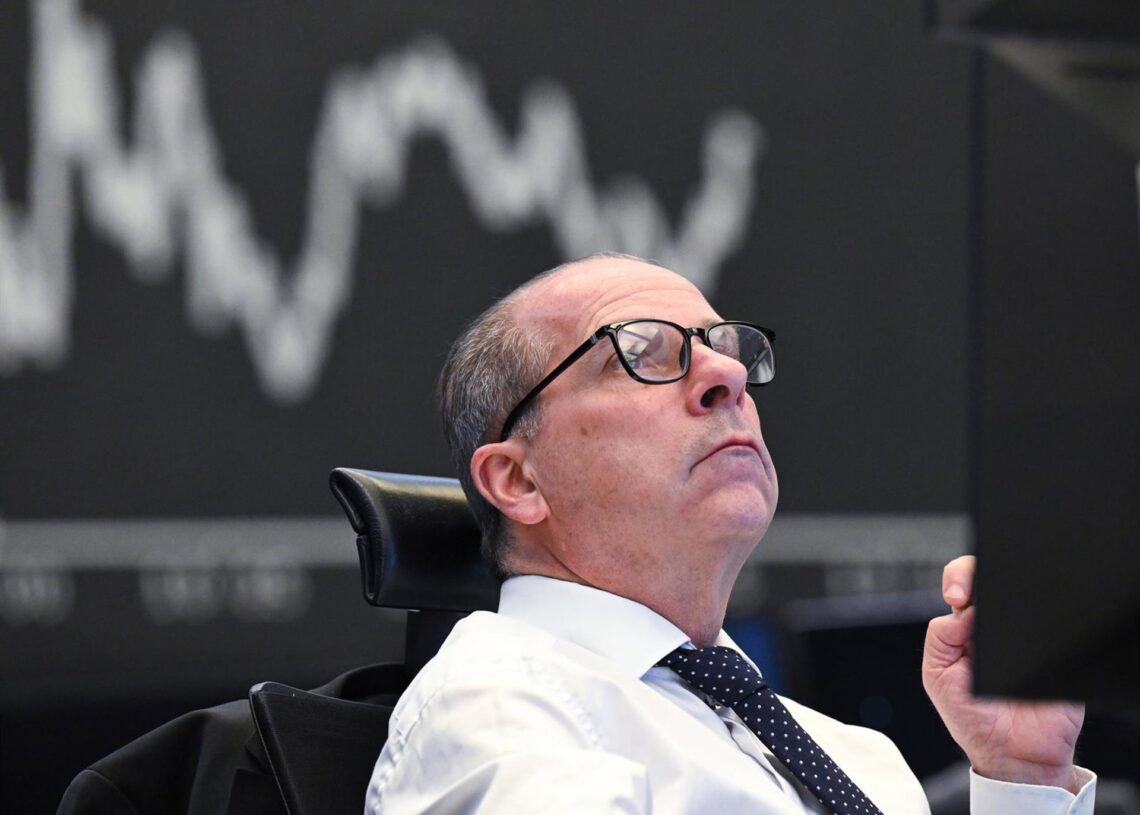 Archivo - 08 April 2025, Hesse, Frankfurt/Main: A trader sits on the trading floor of the Frankfurt Stock Exchange in front of the display board showing the Dax curve. US President Trump's aggressive US tariff policy can also be seen as a trade war againsArne Dedert/dpa - Archivo